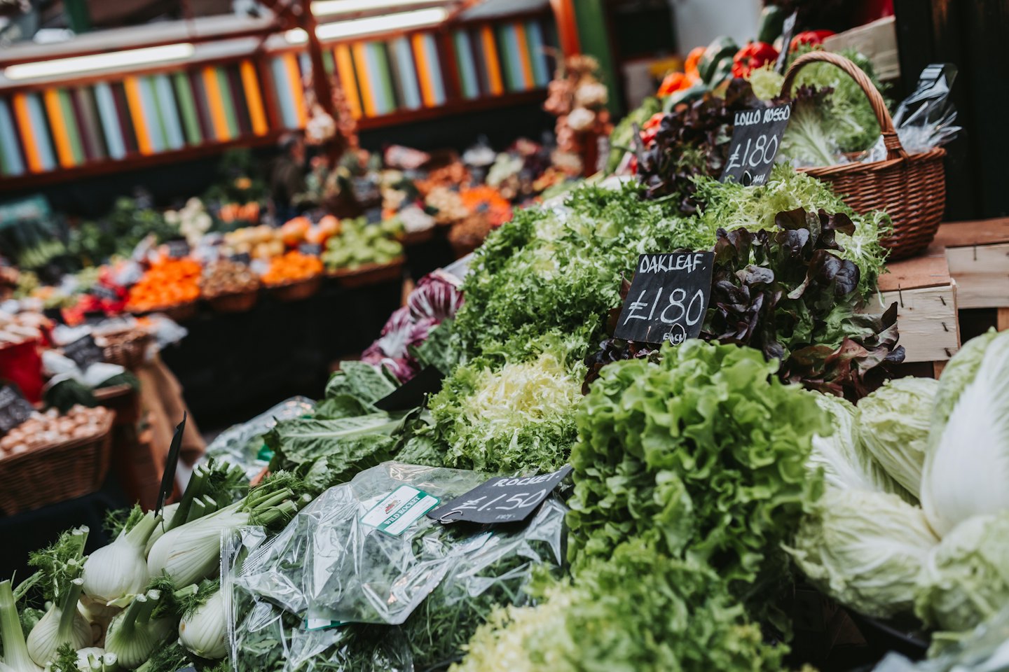 Frisches Blattgemüse, das an einem Marktstand im Freien arrangiert ist.